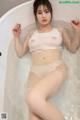 a woman in a white bikini sitting in a bathtub