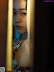 A woman looking out of a window in a dark room.