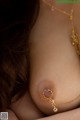 A close up of a woman's breast with a gold necklace.