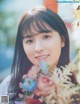 A woman holding a bunch of flowers in her hand.