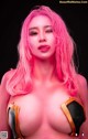 A woman with pink hair is posing for a picture.