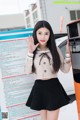 A woman in a school uniform standing next to a vending machine.